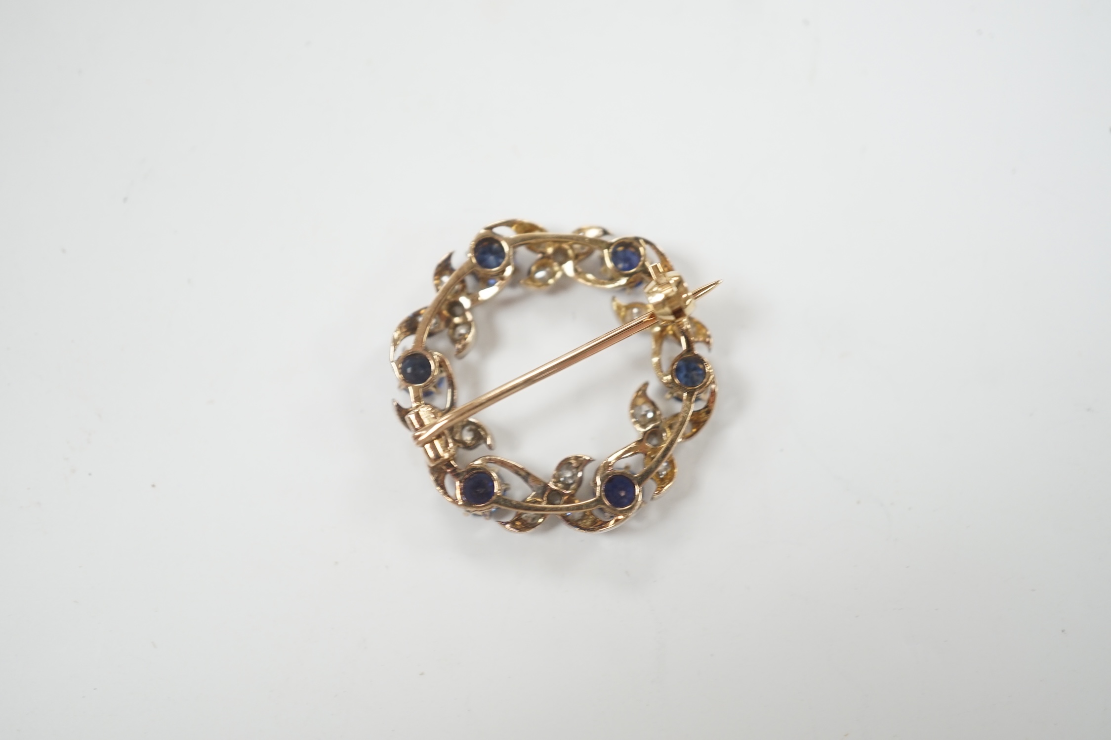 A yellow and white metal, sapphire and diamond cluster set openwork brooch, 24mm, gross weight 4.6 grams.